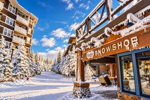 A snow-covered street with a building labeled 'Snowshop' and snow-laden trees. - NEW! Seneca 113: Private Entrance, Hot Tub, Heated Garage, Sleeps 6! (Snowshoe)