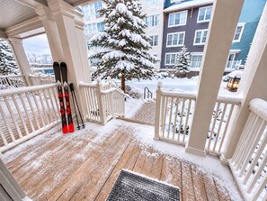 A wooden deck with snow-covered railings and a snow-covered tree in the background. - NEW! Seneca 113: Private Entrance, Hot Tub, Heated Garage, Sleeps 6! (Snowshoe)