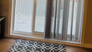 A room with a large sliding glass door leading to an outdoor balcony.