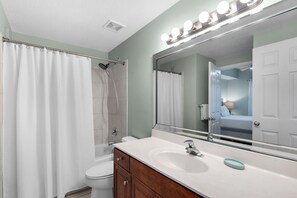 A bathroom with a shower, toilet, vanity with a mirror, and a sink. - Deluxe Views-Short Walk 2 Beach-Resort Amenities (Miramar Beach)