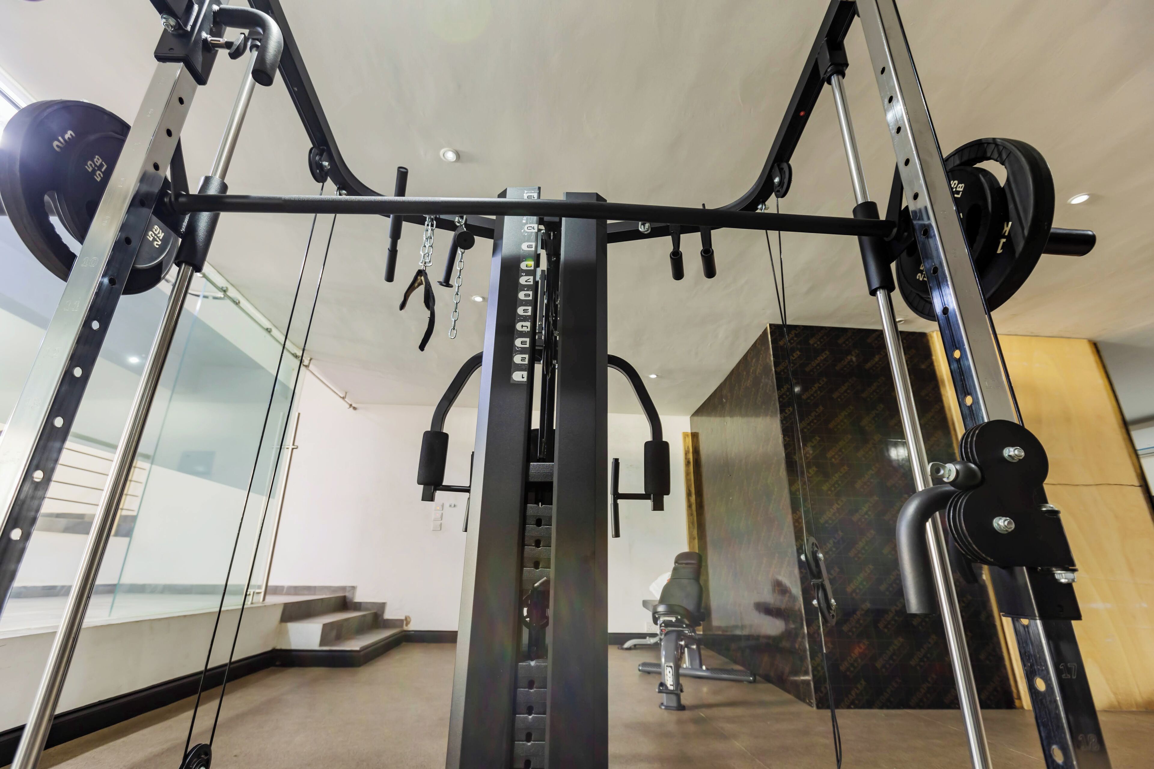 A gym with a weightlifting station, including a squat rack and various weights.