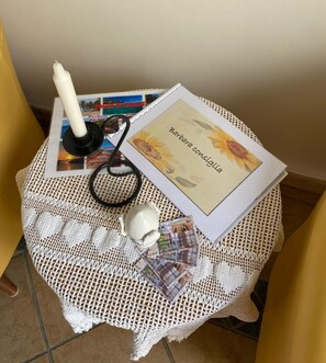 A small table with a crocheted tablecloth, a candle, a stethoscope, a framed picture, and a card with text. - A CASA DI BARBARA A love nest in the heart of Galatina (Galatina)