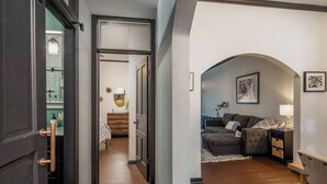 A hallway leading to a living room with a sofa and a lamp. - “Blame Jaime” downtown, the heart of all the fun! (Port Clinton)