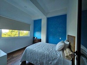 A bedroom with a large bed, a window, and a dresser. - Hotel Familiar Abejac (Puerto Escondido)