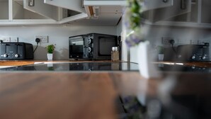 Una cucina con forno a microonde, tostapane e una pianta in vaso.