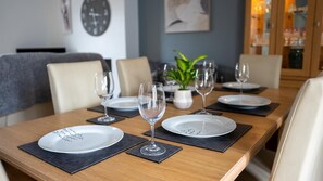 A dining table set with plates, glasses, and a potted plant.