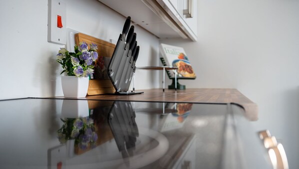A kitchen counter with a knife block, a potted plant, and a cookbook.