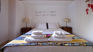 Une chambre d’hôtel comprenant un lit, deux tables de chevet et un mur agrémenté d’un élément décoratif.