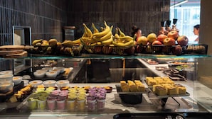 Un bufé con frutas, bollería y postres.