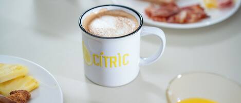 A breakfast setting with a coffee mug labeled "CITRIC," plates of food including toast and eggs, and a glass of orange juice.