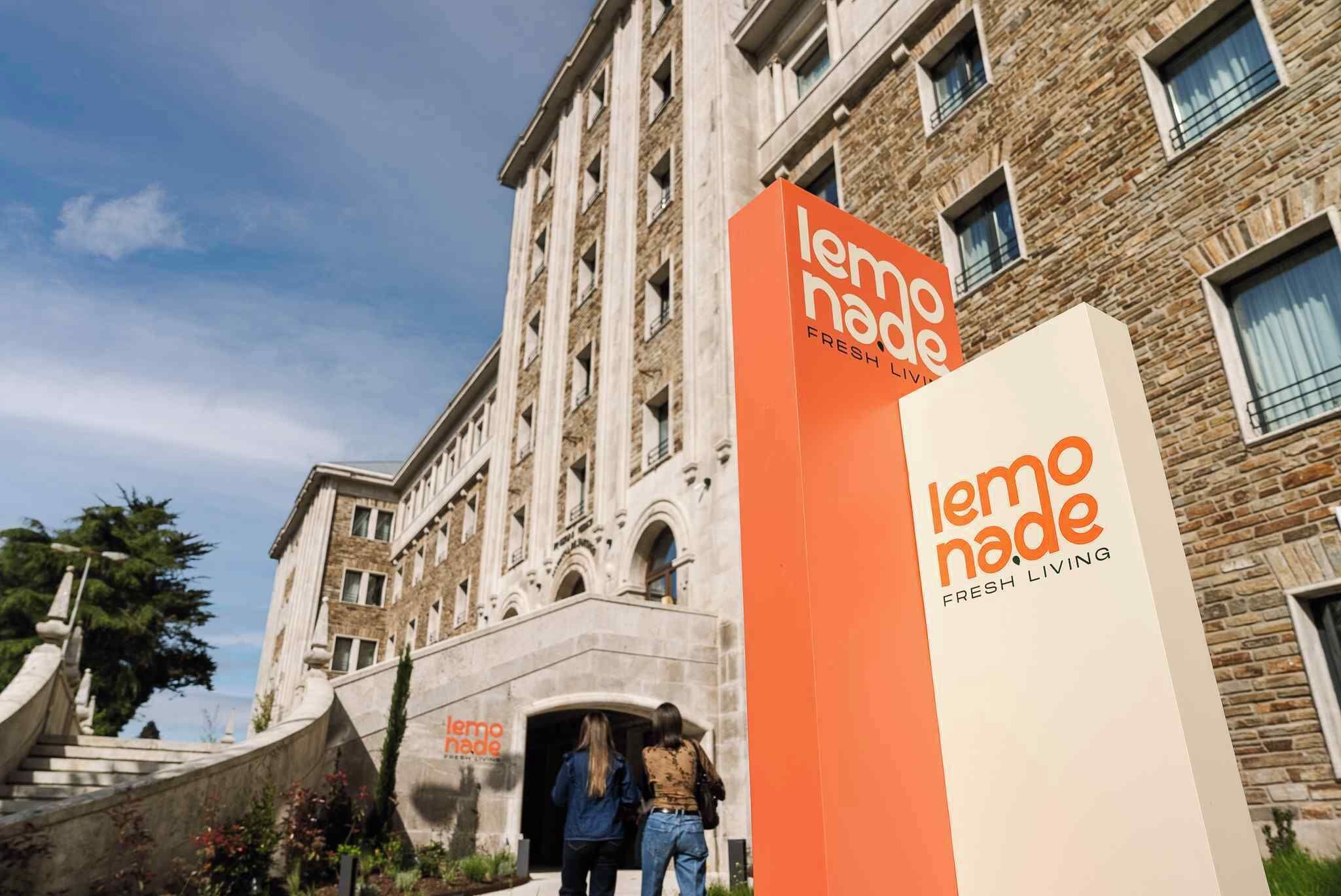 A building with a sign reading 'lemo nado FRESH LIVING' and a staircase leading to an entrance.