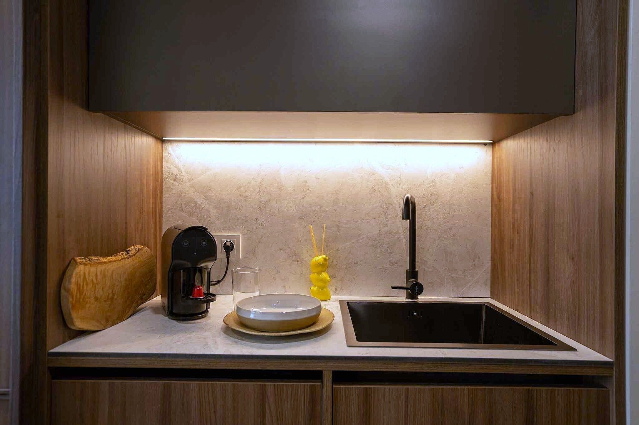 A kitchen with a coffee maker, a sink, and a decorative item.