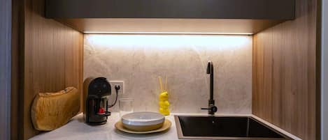 A kitchen with a coffee maker, a sink, and a decorative item.