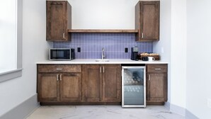 A modern kitchen with wooden cabinets, a microwave, a coffee maker, and a dishwasher. - Brandt House (Alma)