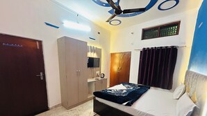 A bedroom with a bed, wardrobe, mirror, and ceiling fan.