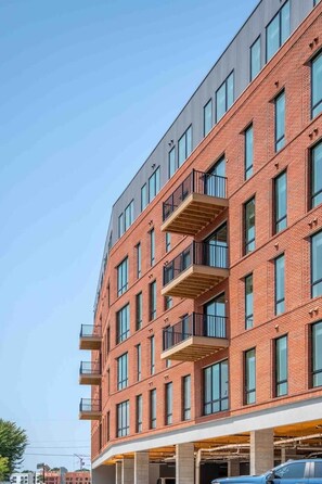 A multi-story building with a brick facade, large windows, and balconies.
