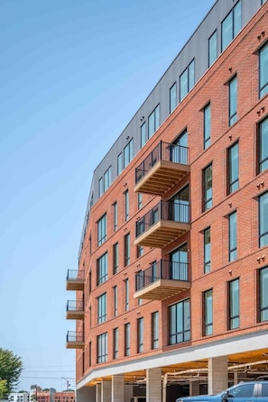 A multi-story building with a brick facade, large windows, and balconies.