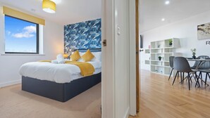 Una camera da letto moderna con un letto grande, una scrivania e un'area pranzo.