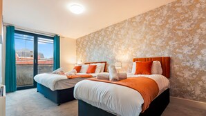 A hotel room with two beds, a balcony, and a patterned wall. - 1 Bed Apartment Sleeps 5 - Balcony - Wifi & Tv (Birmingham)
