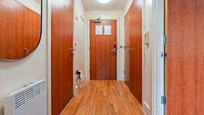 A hallway with wooden doors, a radiator, and a light fixture. - 1 Bed Apartment Sleeps 5 - Balcony - Wifi & Tv (Birmingham)