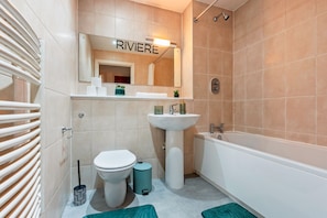 A modern bathroom with a toilet, sink, and bathtub. The word "RIVIERA" is visible on the mirror above the sink. - 1 Bed Apartment Sleeps 5 - Balcony - Wifi & Tv (Birmingham)