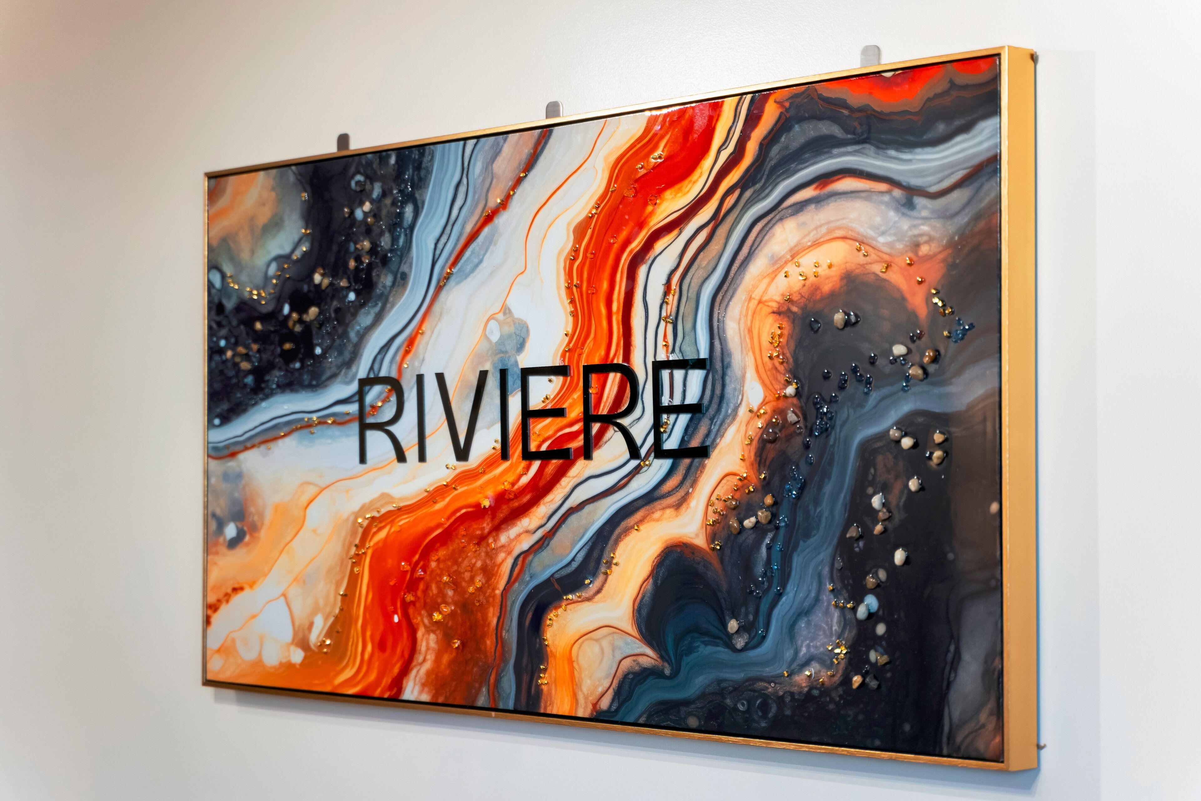 Un quadre abstracte gran amb la paraula "RIVERE" sobre una paret blanca.