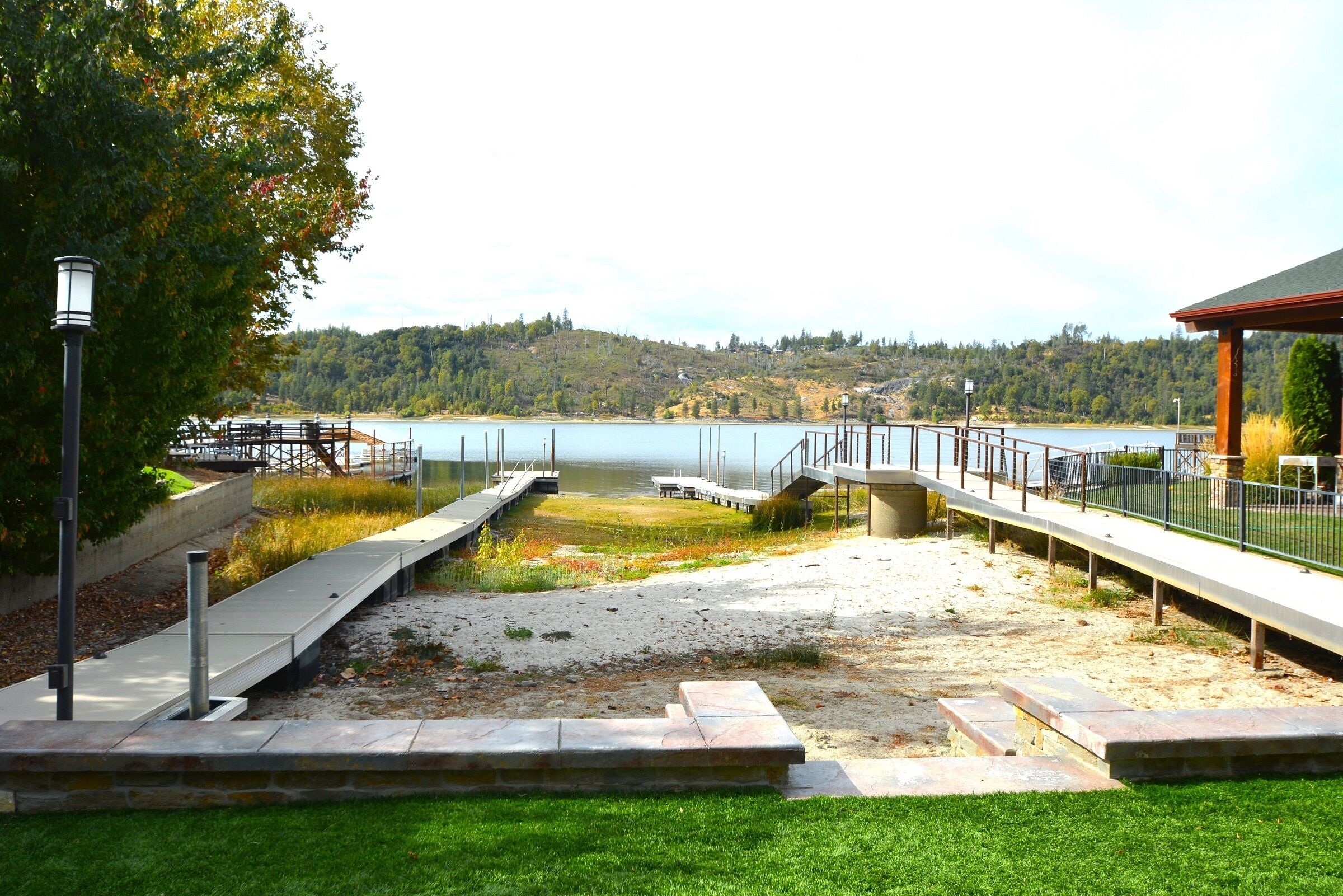 Une promenade en bord de mer dotée d’une terrasse en bois, d’escaliers en pierre et d’une rambarde en métal.