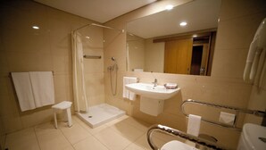 Une salle de bain moderne avec une douche à l’italienne, un lavabo et des toilettes.