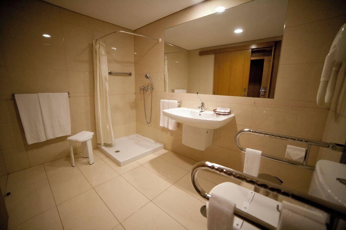 A modern bathroom with a walk-in shower, a sink, and a toilet.