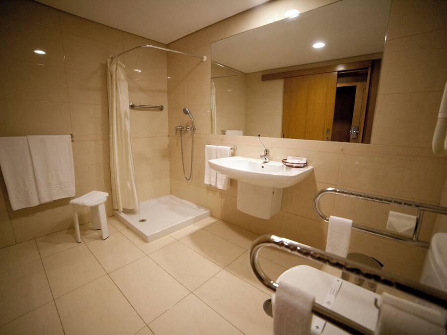 A modern bathroom with a walk-in shower, a sink, and a toilet.