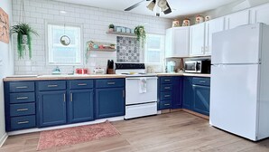 A kitchen with white cabinets, a white stove, and a white refrigerator. - Peaceful water front retreat welcome to Sozo cabin!  (Warsaw)