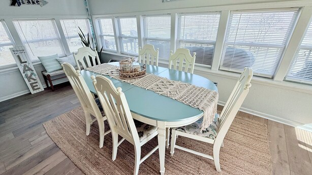 A dining area with a round table, white chairs, a woven placemat, and a 'Relax you're on lake time' sign above. - Peaceful water front retreat welcome to Sozo cabin!  (Warsaw)