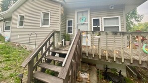 A two-story house with a wooden deck and a staircase leading to the front door. - Peaceful water front retreat welcome to Sozo cabin!  (Warsaw)