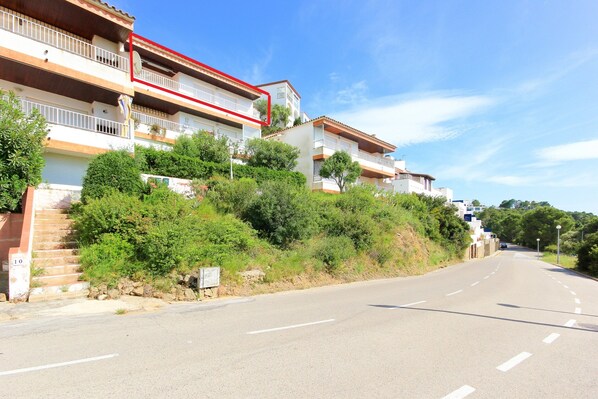 A residential street with houses, a clear sky, and a road with no visible traffic. - Great Apartment With View (Roses)