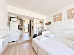 Ein kleines Hotelzimmer mit Bett, einer Küchenzeile und einem Badezimmer.