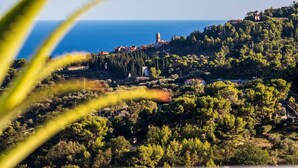A coastal landscape with a prominent tower, lush greenery, and a clear view of the sea. - Large panoramic sea view terrace, stone shower, excellence vacation. (Lingueglietta)