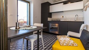 A compact kitchen with a built-in oven, a sink, and a window overlooking a balcony. - Large panoramic sea view terrace, stone shower, excellence vacation. (Lingueglietta)