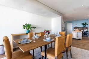 Een eethoek met een houten tafel voor zes personen, omringd door lederen stoelen.