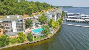 A waterfront hotel with a swimming pool, a dock, and a view of the water. - Harbour Towne 202 - Expansive main channel views! (Lake Ozark)