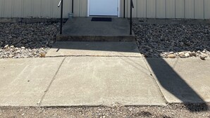A building with a beige exterior, a white door with the number 815, and two windows. - The Power House (Faulkton)