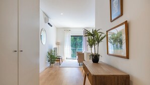 Una sala moderna con una mesa de comedor de madera, plantas en macetas y cuadros en las paredes.