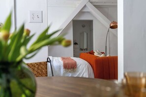 A bedroom with a bed, a nightstand, a lamp, and a view of a hallway. - Urban Studio in Korea Town (Los Angeles)