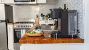 A kitchen with a microwave, stove, and coffee maker on the counter.