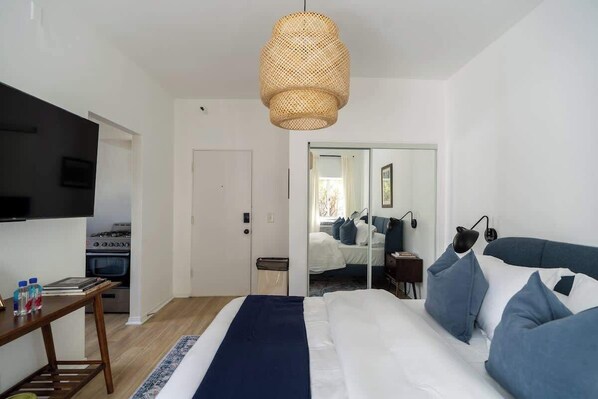 A bedroom with a bed, bedside table, and a television.