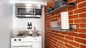 Une cuisine de taille réduite équipée d’un four à micro-ondes, d’une cuisinière et d’un réfrigérateur blanc.