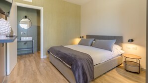 A modern bedroom with a bed, bedside table, and a small bedside lamp.