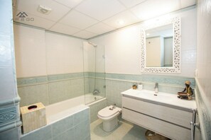Ein Badezimmer mit Badewanne, Toilette und Waschbecken.