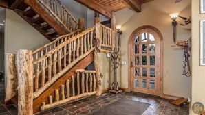 A rustic wooden staircase with a glass door leading to a room. - The Wildflower, Lodge+guest cabins 26 people (Alton)