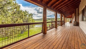 A wooden deck with a view of a green landscape and a lake. - The Wildflower, Lodge+guest cabins 26 people (Alton)