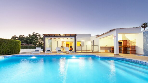 A modern house with a swimming pool, a covered patio, and a kitchen area. - Cozy villa with heatable pool and BBQ (Carvoeiro)